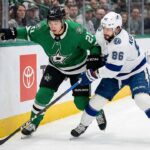Dallas Stars' Jason Robertson and Tampa Bay Lightning's Nikita Kucherov battle for the puck along the boards during a 2026 NHL regular season game.