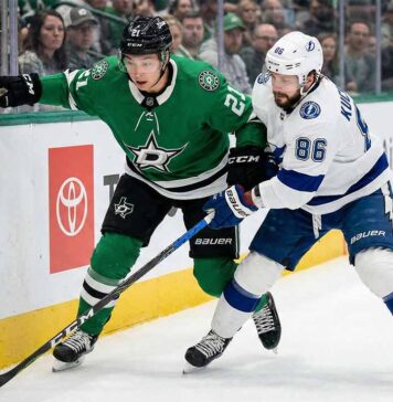 Dallas Stars' Jason Robertson and Tampa Bay Lightning's Nikita Kucherov battle for the puck along the boards during a 2026 NHL regular season game.