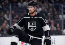 A mock-up concept image showing NHL forward Steven Stamkos wearing a black Los Angeles Kings home jersey and helmet, kneeling on the ice rink during a game setting.