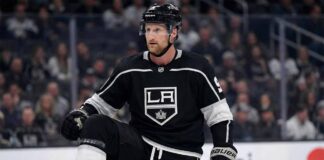 A mock-up concept image showing NHL forward Steven Stamkos wearing a black Los Angeles Kings home jersey and helmet, kneeling on the ice rink during a game setting.