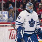 Toronto Maple Leafs goaltender Anthony Stolarz (#41) stands in his crease during a game. Behind the protective glass, a female fan in a Leafs jersey and beanie holds a handwritten sign that reads, "GOOD LUCK ON YOUR NEW TEAM ANTHONY!".