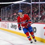 Montreal Canadiens defenseman Arber Xhekaj (72) skating along the boards at the Bell Centre, passing advertisements for Coca-Cola, Jeep, and TSN.