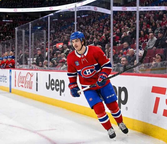 Montreal Canadiens defenseman Arber Xhekaj (72) skating along the boards at the Bell Centre, passing advertisements for Coca-Cola, Jeep, and TSN.