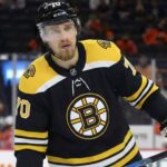 Defenseman Rasmus Ristolainen is pictured on the ice wearing a black Boston Bruins home jersey with the number 70 on the helmet and sleeves, holding his hockey stick and looking toward the crowd.