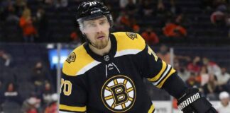 Defenseman Rasmus Ristolainen is pictured on the ice wearing a black Boston Bruins home jersey with the number 70 on the helmet and sleeves, holding his hockey stick and looking toward the crowd.