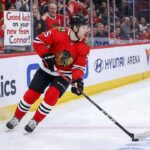 Connor Murphy, Chicago Blackhawks defenseman, skated with the puck during an NHL game with the message "GOOD LUCK ON YOUR NEW TEAM CONNOR!" written on the rink glass, fueling trade rumors to the Dallas Stars and Boston Bruins in 2026.