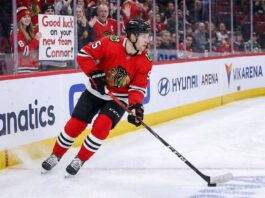 Connor Murphy, Chicago Blackhawks defenseman, skated with the puck during an NHL game with the message "GOOD LUCK ON YOUR NEW TEAM CONNOR!" written on the rink glass, fueling trade rumors to the Dallas Stars and Boston Bruins in 2026.