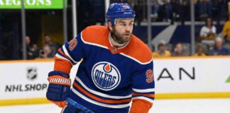 Edmonton Oilers center Ryan O'Reilly (90) skating on the ice in a royal blue home jersey during an NHL game.