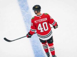 An overhead view of NHL player Elias Pettersson skating on an ice rink, wearing a red Chicago Blackhawks home uniform with the name "PETTERSSON" and number "40" on the back.