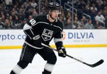 Elias Pettersson, wearing a black Los Angeles Kings #40 jersey and helmet, stands on the ice holding his hockey stick during a game.