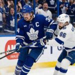 Toronto Maple Leafs captain Auston Matthews battles for possession of the puck against Tampa Bay Lightning forward Nikita Kucherov along the boards during an NHL game at Amalie Arena.
