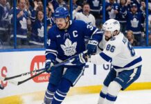 Toronto Maple Leafs captain Auston Matthews battles for possession of the puck against Tampa Bay Lightning forward Nikita Kucherov along the boards during an NHL game at Amalie Arena.