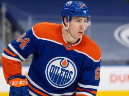 Why the Edmonton Oilers Are Pivoting to Winnipeg Jets’ Logan Stanley Edmonton Oilers defenseman Logan Stanley, wearing number 64 in a blue home jersey, looking to his left while on the ice during a game.