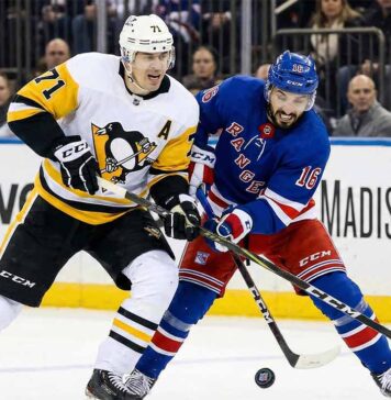 Will the Crosby-Less Pittsburgh Penguins Crush the New York Rangers? Pittsburgh Penguins center Evgeni Malkin (#71) and New York Rangers center Vincent Trocheck (#16) battle for a loose puck during an NHL game at Madison Square Garden.