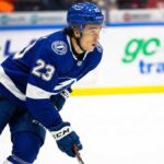 Tampa Bay Lightning prospect Sam O'Reilly, wearing a blue number 23 jersey and helmet, skating on the ice during game action.