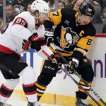 Senators vs Penguins Live Stream: How to Watch, Odds & Prediction (Feb 2, 2026) Pittsburgh Penguins captain Sidney Crosby #87 battling for puck possession against Ottawa Senators defenseman Jake Sanderson #85 along the boards during an NHL game.