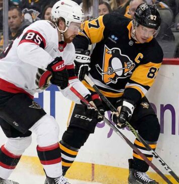 Senators vs Penguins Live Stream: How to Watch, Odds & Prediction (Feb 2, 2026) Pittsburgh Penguins captain Sidney Crosby #87 battling for puck possession against Ottawa Senators defenseman Jake Sanderson #85 along the boards during an NHL game.