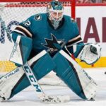 Sergei Bobrovsky pictured in a full teal and black San Jose Sharks goaltending uniform, positioned in a butterfly stance on the ice in front of the net.