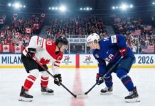 Team Canada captain Marie-Philip Poulin (left, #29) and Team USA forward Hilary Knight (right, #21) are crouched and ready for a face-off at center ice during a women's ice hockey game at the Milano Cortina 2026 Winter Olympics. The arena is filled with spectators waving Canadian and American flags, and banners reading "MILANO 2026" are visible on the boards.