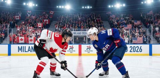 Team Canada captain Marie-Philip Poulin (left, #29) and Team USA forward Hilary Knight (right, #21) are crouched and ready for a face-off at center ice during a women's ice hockey game at the Milano Cortina 2026 Winter Olympics. The arena is filled with spectators waving Canadian and American flags, and banners reading "MILANO 2026" are visible on the boards.