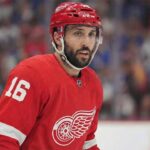 NHL center Vincent Trocheck depicted wearing a Detroit Red Wings home jersey with the number 16 and a corresponding red helmet while on the ice during a game.