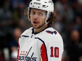 Artemi Panarin in a white Washington Capitals jersey and helmet, number 10, looking towards the right with his tongue out.