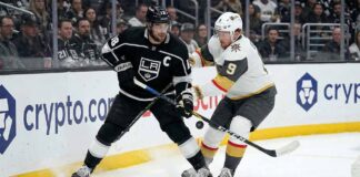Los Angeles Kings captain Anze Kopitar (left) and Vegas Golden Knights forward Jack Eichel (right) battle fiercely for puck possession along the boards at Crypto.com Arena during an NHL game.