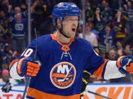 Vancouver Canucks center Elias Pettersson, wearing the 'Flying Skate' retro jersey, celebrating a goal, amidst New York Islanders trade speculation.
