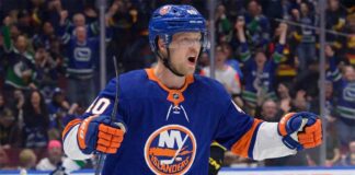 Vancouver Canucks center Elias Pettersson, wearing the 'Flying Skate' retro jersey, celebrating a goal, amidst New York Islanders trade speculation.