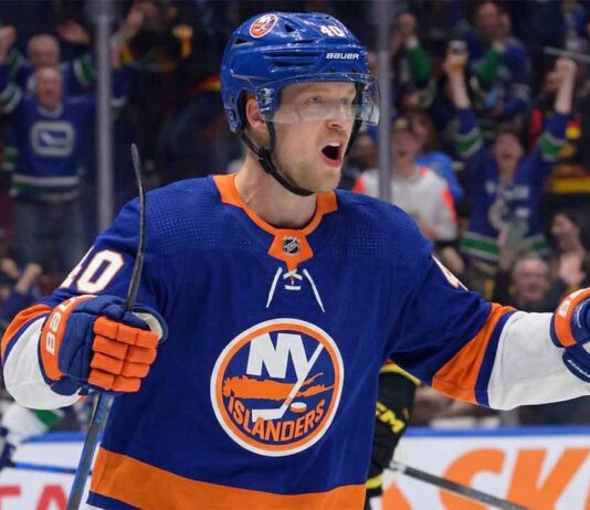 Elias Pettersson Trade Rumors: NY Islanders & Canucks Potential Deal Vancouver Canucks center Elias Pettersson, wearing the 'Flying Skate' retro jersey, celebrating a goal, amidst New York Islanders trade speculation.