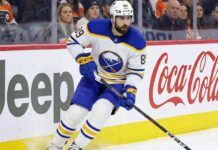 Buffalo Sabres winger Alex Tuch (number 89) skating hard along the rink boards featuring Jeep and Coca-Cola advertising during a home game. This image relates to current discussions about Tuch's contract extension and potential free agency.
