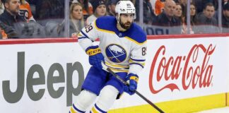 Buffalo Sabres winger Alex Tuch (number 89) skating hard along the rink boards featuring Jeep and Coca-Cola advertising during a home game. This image relates to current discussions about Tuch's contract extension and potential free agency.