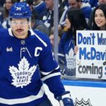 The Unthinkable Reality: Is Auston Matthews Done With the Toronto Maple Leafs? Toronto Maple Leafs captain Auston Matthews skates by the boards as a fan holds a controversial sign reading 'Don't Worry Auston, McDavid is coming soon!' highlighting fan frustration and future roster rumors.