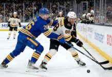 Buffalo Sabres defenseman Rasmus Dahlin checks Boston Bruins forward David Pastrnak along the boards during an NHL game at KeyBank Center.