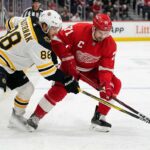 How to Watch Boston Bruins vs Detroit Red Wings | TV Channel & Time Boston Bruins David Pastrnak and Detroit Red Wings Dylan Larkin battle intensely for a puck near the boards at Little Caesars Arena during an Atlantic Division matchup.