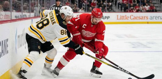 How to Watch Boston Bruins vs Detroit Red Wings | TV Channel & Time Boston Bruins David Pastrnak and Detroit Red Wings Dylan Larkin battle intensely for a puck near the boards at Little Caesars Arena during an Atlantic Division matchup.