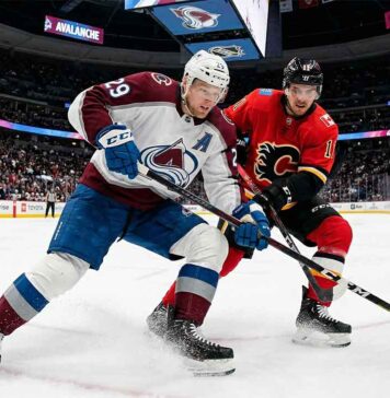 What Channel is the Calgary Flames vs Colorado Avalanche Game On Tonight? | TV & Stream Guide An action photograph capturing Colorado Avalanche forward Nathan MacKinnon and Calgary Flames forward Mikael Backlund in an intense stick battle for the puck on the ice at Ball Arena in Denver during a regular season NHL game.