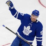 Connor McDavid Trade Rumors: Will He Leave the Edmonton Oilers? View of superstar Connor McDavid wearing a Toronto Maple Leafs away jersey with number 97, illustrating potential future NHL trade rumors and free agency speculation.