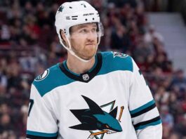 San Jose Sharks Trade Rumors: Will Dougie Hamilton Waive His NTC? Pensive Dougie Hamilton wearing a white San Jose Sharks away uniform with teal accents, illustrating potential NHL trade rumors.