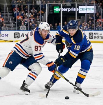 Edmonton Oilers captain Connor McDavid (#97) battling St. Louis Blues forward Robert Thomas (#18) for puck possession during an NHL regular season game at Enterprise Center in St. Louis.