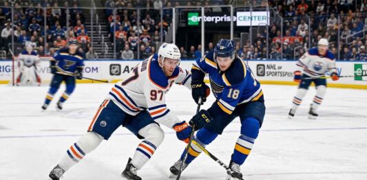 Edmonton Oilers captain Connor McDavid (#97) battling St. Louis Blues forward Robert Thomas (#18) for puck possession during an NHL regular season game at Enterprise Center in St. Louis.