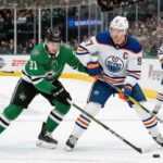 Edmonton Oilers captain Connor McDavid (#97) battles Dallas Stars forward Jason Robertson (#21) at a face-off dot during a regular-season NHL game.