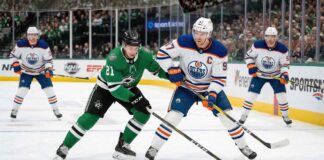 Edmonton Oilers captain Connor McDavid (#97) battles Dallas Stars forward Jason Robertson (#21) at a face-off dot during a regular-season NHL game.