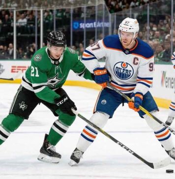 Edmonton Oilers captain Connor McDavid (#97) battles Dallas Stars forward Jason Robertson (#21) at a face-off dot during a regular-season NHL game.