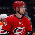 Elias Pettersson Trade Rumors: Vancouver Canucks to Carolina Hurricanes Elias Pettersson of the Vancouver Canucks, wearing the blue orca jersey, looks focused on the ice during an NHL game, fueling trade rumors linking him to the Carolina Hurricanes.