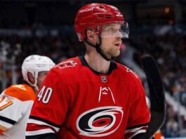 Elias Pettersson Trade Rumors: Vancouver Canucks to Carolina Hurricanes Elias Pettersson of the Vancouver Canucks, wearing the blue orca jersey, looks focused on the ice during an NHL game, fueling trade rumors linking him to the Carolina Hurricanes.