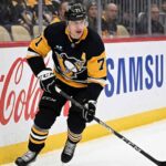 Pittsburgh Penguins center Evgeni Malkin (71) skating along the boards with the puck.