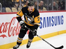 Pittsburgh Penguins center Evgeni Malkin (71) skating along the boards with the puck.