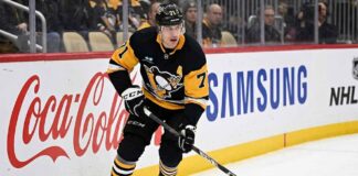 Pittsburgh Penguins center Evgeni Malkin (71) skating along the boards with the puck.