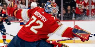 Florida Panthers goaltender Sergei Bobrovsky (72) makes a dramatic full-split save against Edmonton Oilers star Connor McDavid during a high-stakes NHL game. Bobrovsky is wearing his signature red Panthers uniform and CCM goalie gear.